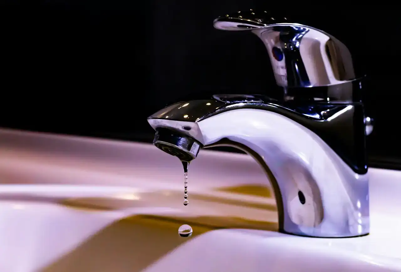 Chrome bathroom faucet with a drip falling from the spout